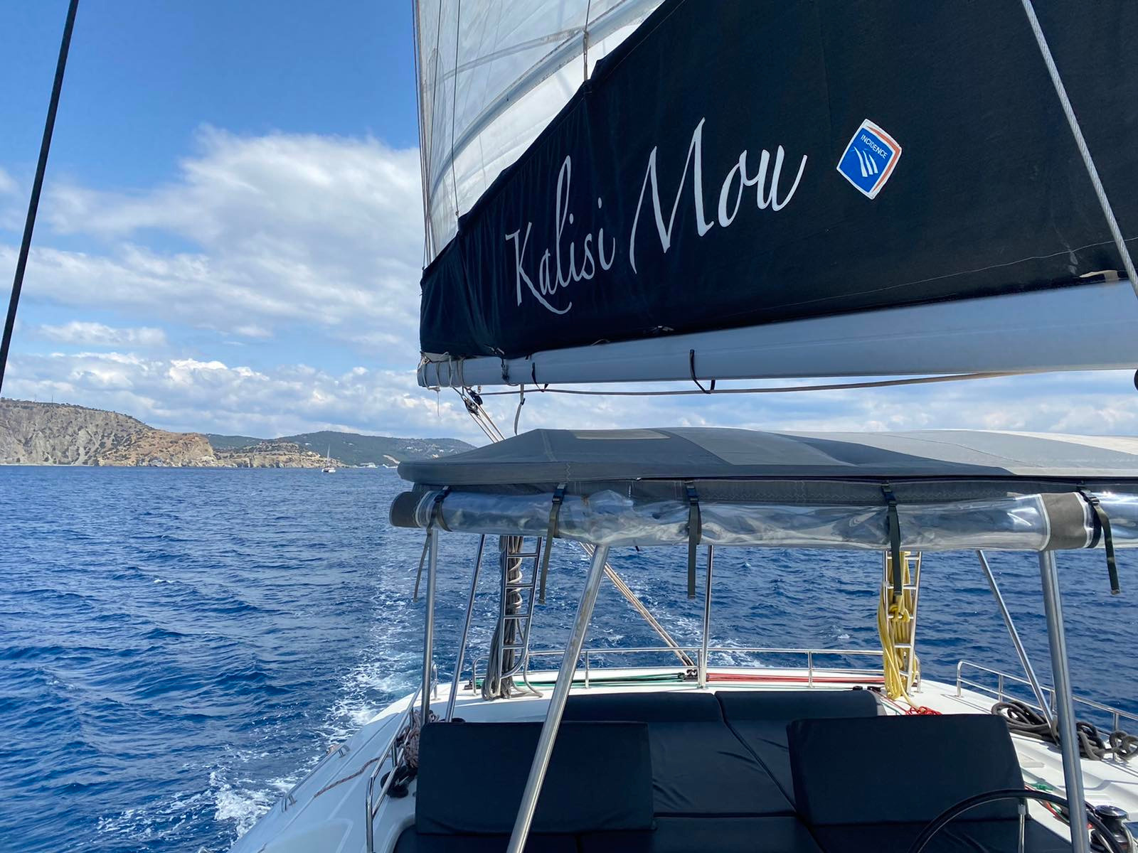 Kalisi Mou under sail with branded mainsail